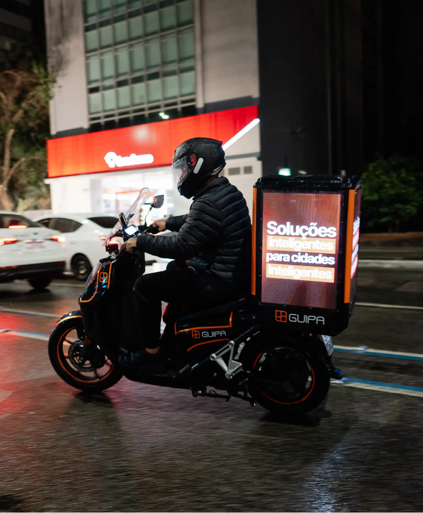 Condutor GUIPA com moto elétrica e painel publicitário digital